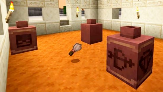 Fecha de lanzamiento de Minecraft 1.20 características: arqueología de Minecraft, mostrando tres macetas diferentes y el pincel del arqueólogo, en el suelo de un edificio del desierto